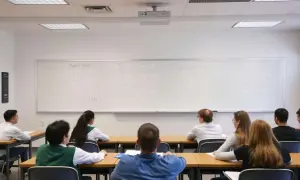 Estudiantes en clase de matemáticas, con ecuaciones en la pizarra. ¿Cuántas bolas se sacan en oposiciones de secundaria?