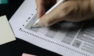 Mano completando una hoja de respuestas tipo test. ¡Descubre trucos para aprobar oposiciones tipo test y domina el examen!