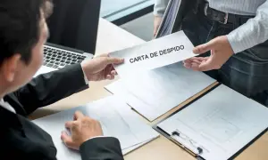 Un hombre entrega una carta de despido. El receptor, con traje, revisa documentos. Se siente la tensión de las mentiras en la carta de despido.