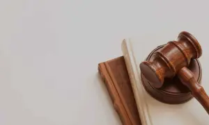 Mazo de juez sobre libros, simbolizando la lucha contra la precariedad laboral y la búsqueda de justicia.