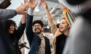 Un grupo de personas celebra con un choque de manos, mostrando un gran espíritu de equipo y alegría.