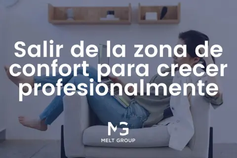 Mujer relajada en un sofá con portátil, reflexionando sobre salir de su zona de confort para crecer profesionalmente.