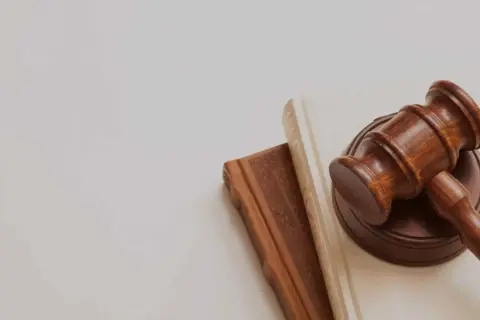 Mazo de juez sobre libros, simbolizando la lucha contra la precariedad laboral y la búsqueda de justicia.