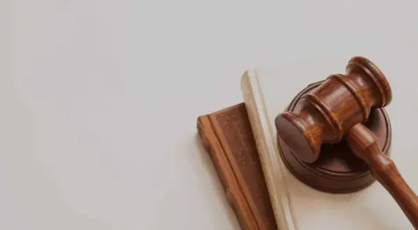 Mazo de juez sobre libros, simbolizando la lucha contra la precariedad laboral y la búsqueda de justicia.