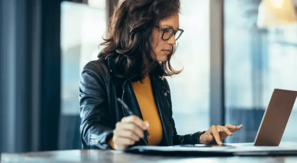 Mujer concentrada en su portátil, aprendiendo con un curso ofimática homologado.