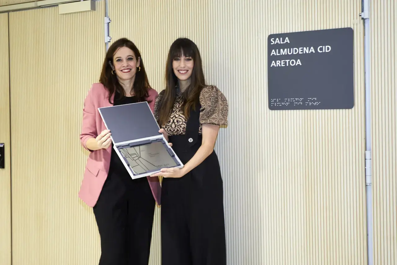 Dos mujeres posan con un reconocimiento en la Sala Almudena Cid. Las opiniones sobre Almudena Palacios son positivas.