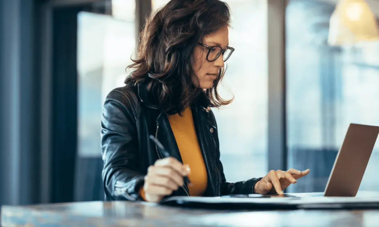 Mujer concentrada en su portátil, aprendiendo con un curso ofimática homologado.