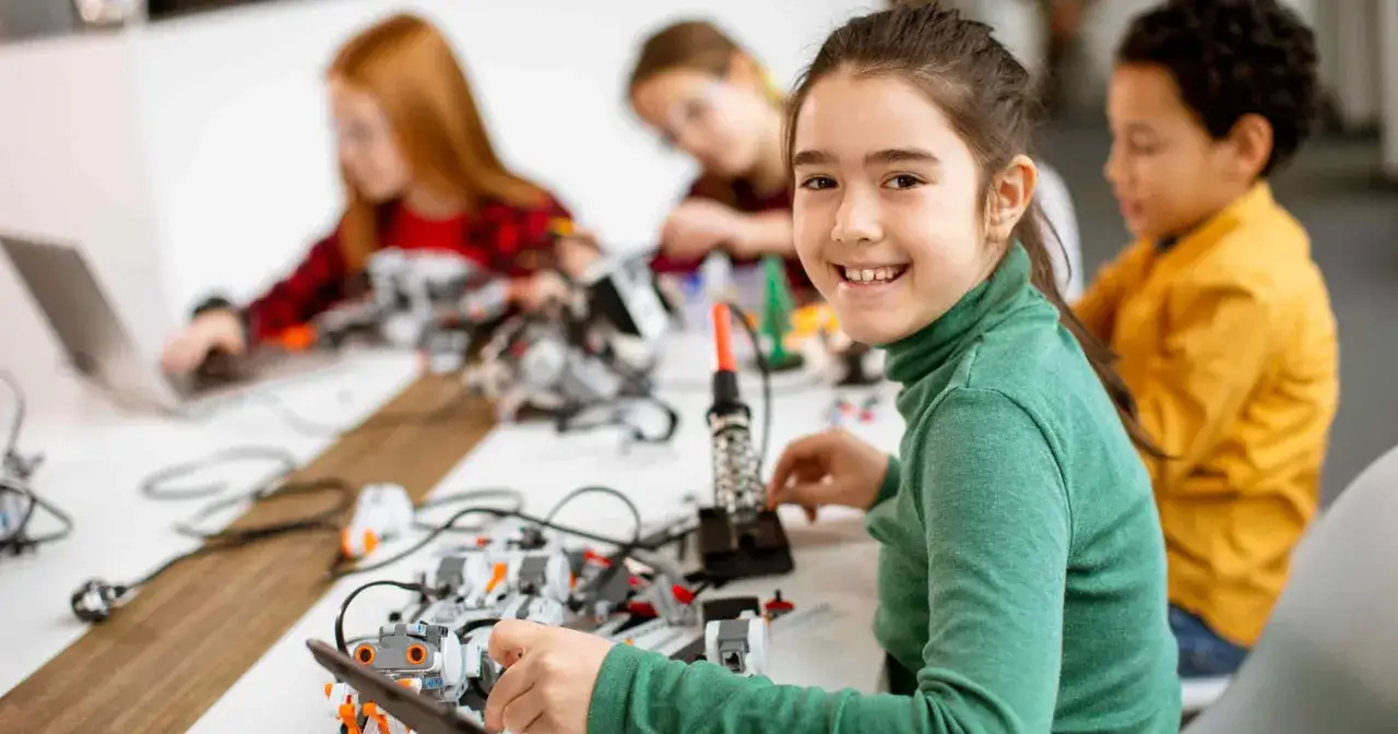 Niños construyendo robots, aprendiendo sobre el temario tecnología.