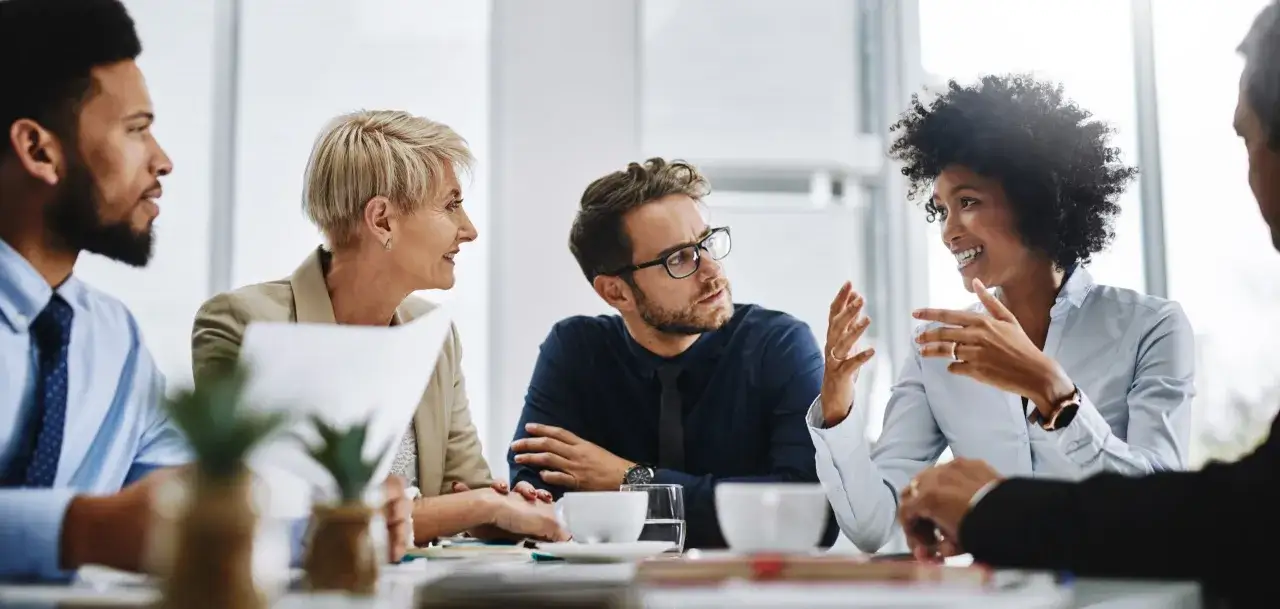 Equipo diverso en reunión discutiendo estrategias, explorando el outsourcing que es y cómo optimizar procesos.