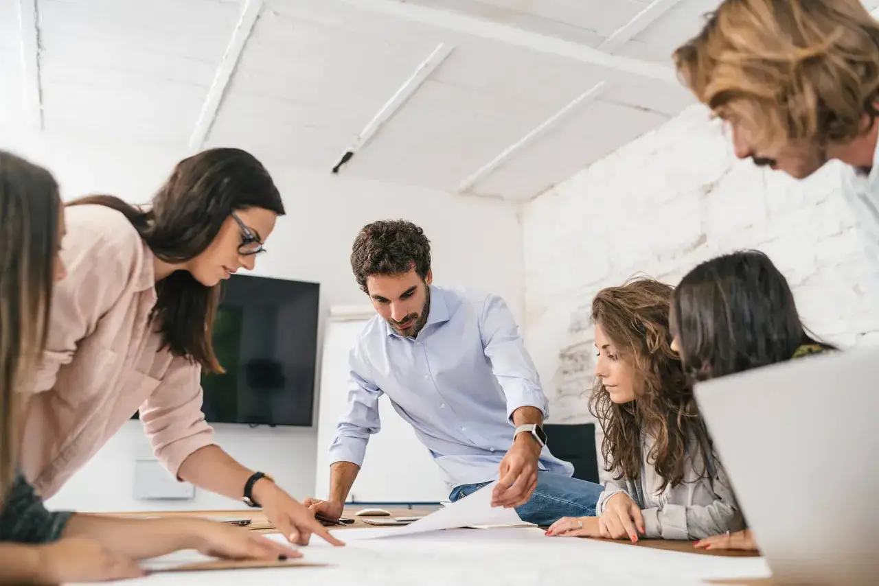 Equipo colaborando en un proyecto, demostrando la definici&oacute;n de inteligencia emocional al trabajar juntos.