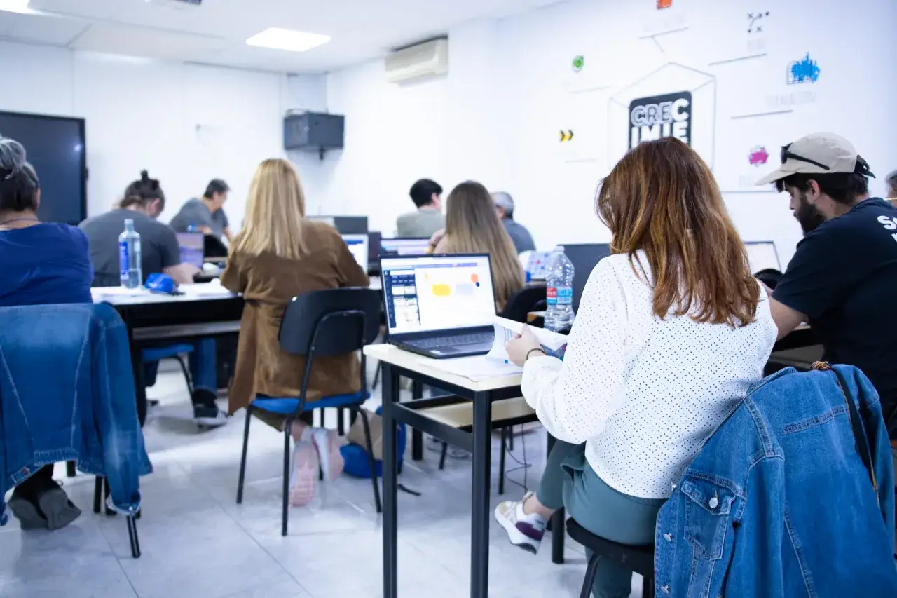 Estudiantes en clase, aprendiendo en sus ordenadores. Un ambiente ideal para realizar cursos homologados Valencia.