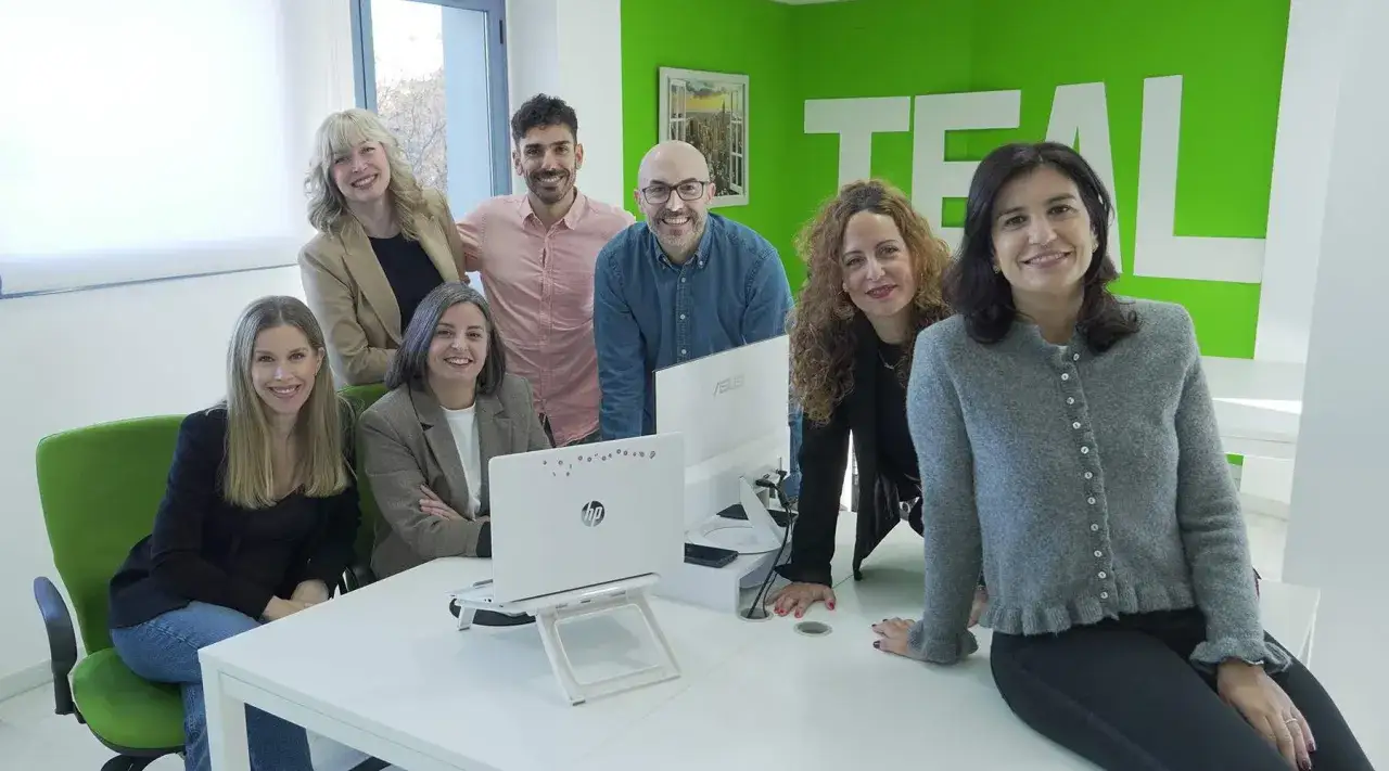 Equipo de consultores de RRHH sonríe en una oficina moderna.