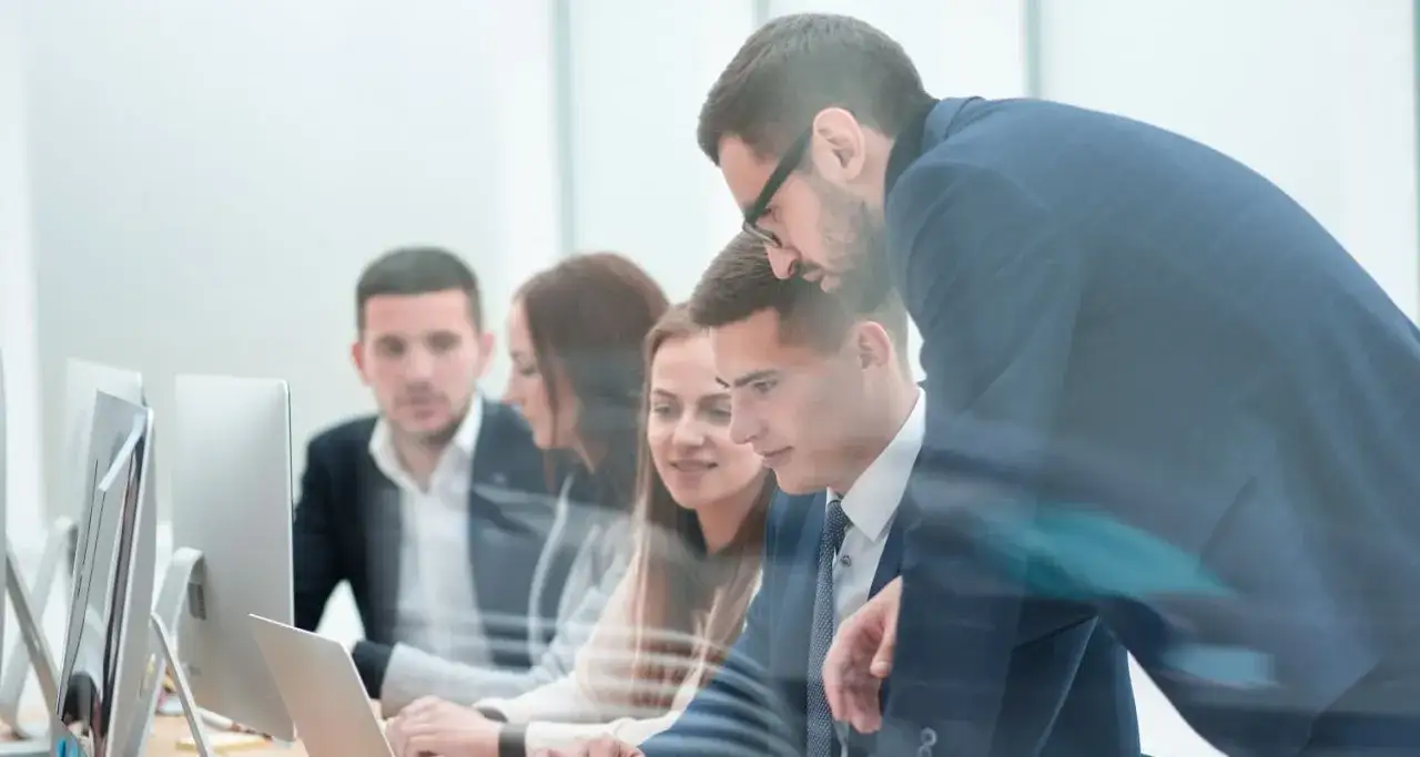 Equipo colaborando en la oficina, discutiendo modelos de gesti&oacute;n y estrategias de trabajo.