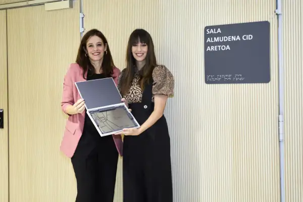 Dos mujeres posan con un reconocimiento en la Sala Almudena Cid. Las opiniones sobre Almudena Palacios son positivas.