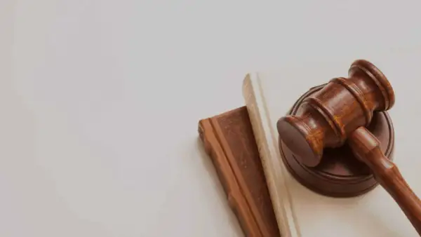 Mazo de juez sobre libros, simbolizando la lucha contra la precariedad laboral y la búsqueda de justicia.